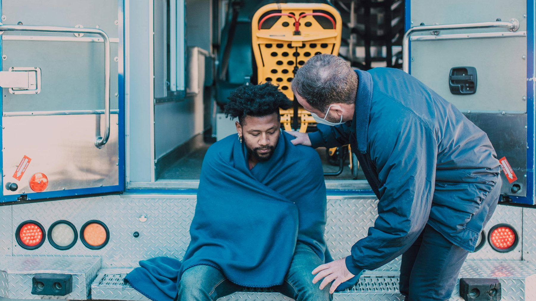 Paramedic attending to a patient at the rear of an ambulance